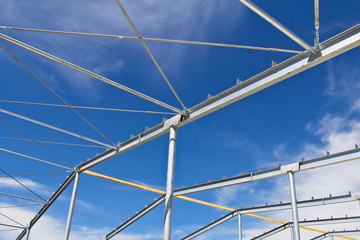 Fototapeta premium Part of the building structure of galvanized parts. Galvanized parts on a construction site in sunny weather. Installation of metal structures. Galvanized metal is not exposed to corrosion.