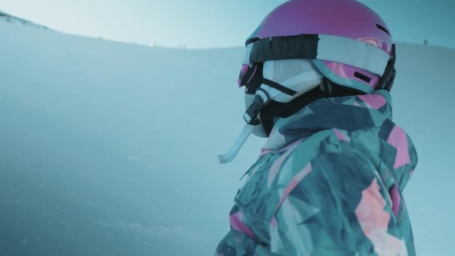 Medium shot of a young girl looking up at the Dolomites ski hills in Belluno, Italy.