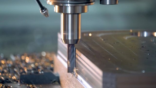 CNC milling machine cutting steel in a machine shop.