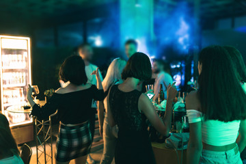 Young people and friends dancing and enjoying in the nightclub. People in night club. Dancing, drinking and having fun.
