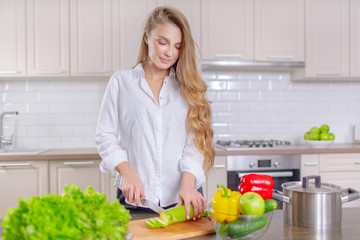 Beautiful girl prepares healthy food, slices zucchini