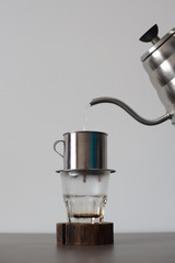 Traditional Vietnamese drip filtered coffee making. Pouring hot water into phin minimalist style