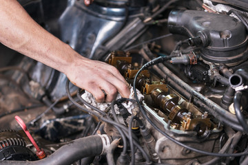 Fototapeta na wymiar Auto mechanic working on car engine at repair service. Close up view .