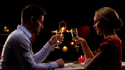 Sweet passionate couple on romantic date drinking champagne, Valentines day