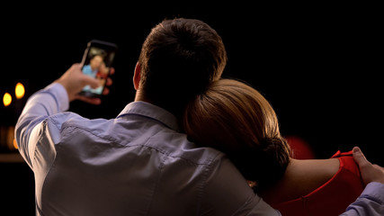 Nice couple on romantic date taking selfie, celebrating anniversary, back view