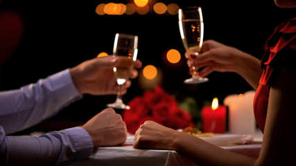 Young couple with champagne on romantic evening, celebrating anniversary, love