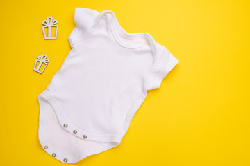 mockup Flat Lay white children’s shirt with toys on a yellow background. Layout for the design and placement of logos, advertising, children's party baby shower, children's birthday