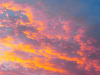 Dramatic sunset sky background with fiery clouds, yellow, orange and pink colors