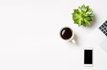 Laptop computer with plant in a pot, cup of coffee and modern mobile phone on white background. Conceptual workspace or business concept. Free space for your text