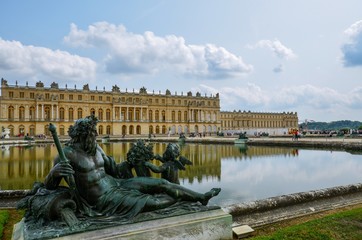 Statue and reflecting pool in front of Palace of Versailles in France