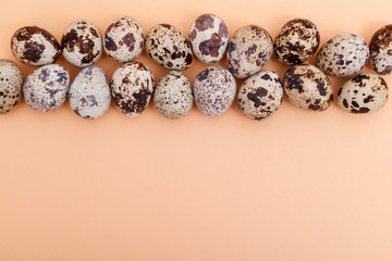 Quail eggs on light pink solid background with copy space, top view. Health food. Easter background