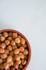 casserole of chick-peas cooked on white fund.boiled chickpeas in a clay pot close up. copy spase.Boiled chickpeas in a bowl.traditional Turkish cuisine