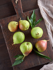 ripe green pears on a brown wooden board