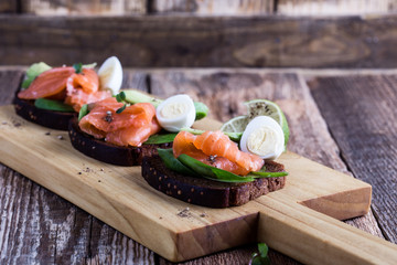 Toasted rye bread with  smoked salmon and fresh green vegetables
