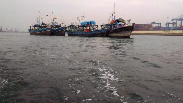 Three large boats on Manora Beach. A smaller motorboat captures this video footage as it swiftly goes by the three larger ships.