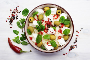 Warm salad of couscous, soft cheeses, olive and hot peppers. Healthy and tasty homemade dish