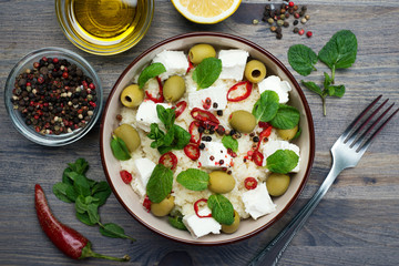 Warm salad of couscous, soft cheeses, olive and hot peppers. Healthy and tasty homemade dish