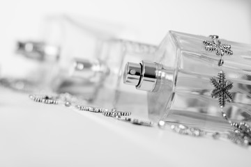 Transparent perfume bottles with dispensers lie on a white surface. Beauty industry
