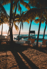 Beautiful sunset in Trou aux Biches, Mauritius. View of the jetty and boats amidst palm trees