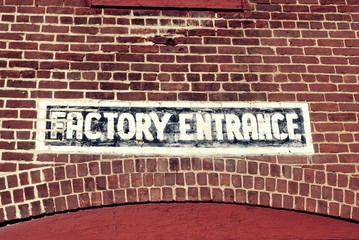 painted factory entrance sign on brick building