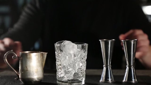 White Russian cocktail. The bartender prepares it in a glass of ice