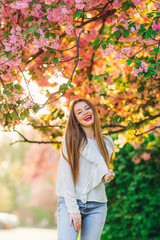 A girl with long hair smiles and looks at the camera lens. over