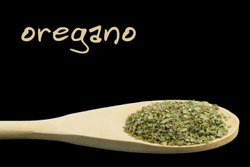 oregano on wooden spoon isolated on black background