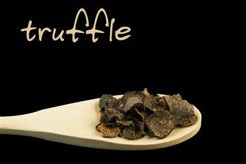 truffle on wooden spoon isolated on black background