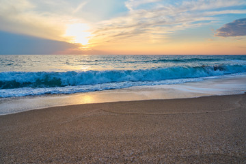  Tropical sandy beach. Sunset seascape. Waves with foam hitting sand.