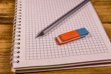 Open notepad and different stationeries on a wooden table