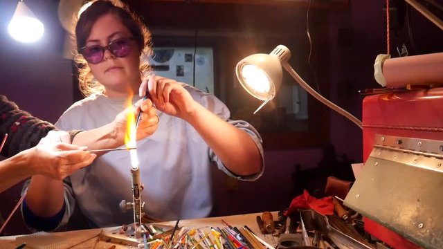 Young Woman Learning Lampwork with Help of Bead Making Instructor