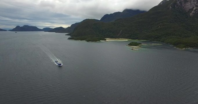 Aerial view with drone of a well-boat sailing through the channels of Chilean Patagonia