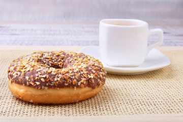 Coffee break with fresh donuts over textile background.