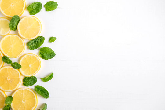 Fresh lemon slices on a white background. Background with lemon and mint. Beautiful photo with citrus. Vitamin C. Lemon and Fresh Mint Pattern