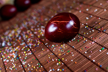 Red easter egg on a table, unstable composition 