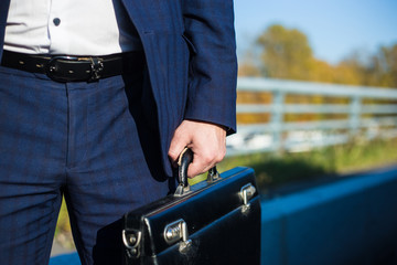 .a businessman standing near in front of.luxury car holding brief case or diplomat