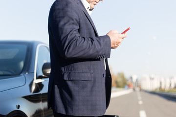 .a businessman standing near in front of.luxury car holding brief case or diplomat