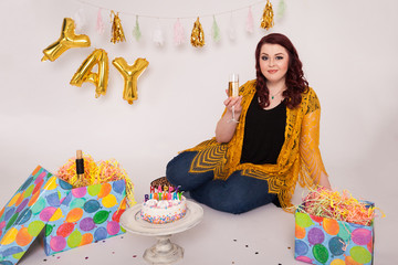 Young beautiful women birthday photo session posing holding glass of wine cute smile birthday decorations gifts and cake 