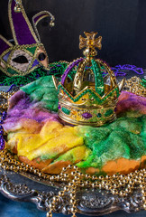 king cake with crown surrounded by mardi gras beads © Lynne Ann Mitchell