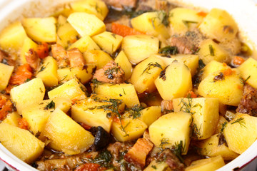 Cast iron plate with sliced grilled rib cooking a medium steak with fried potato and spices.