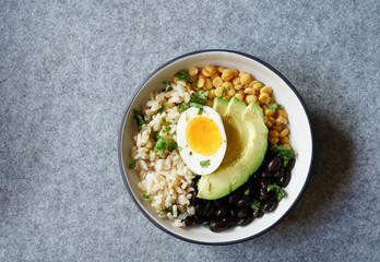 Brown rice lentil avocado salad in a bowl, top down view