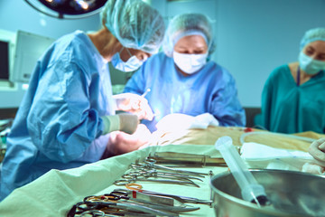 Tray with surgical instruments in the foreground in operating room, plastic surgery - Chin...