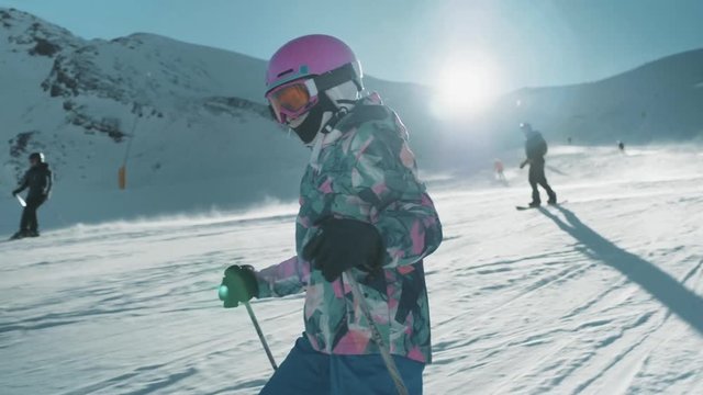 Gorgeous dolly shot following a young girl carving down the snowy slopes of a ski hill in Italy.