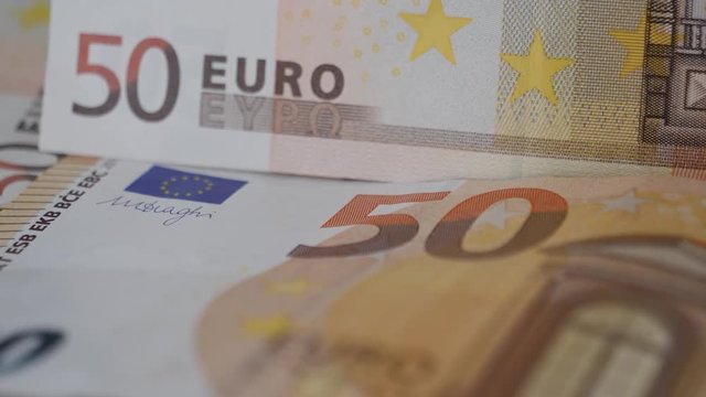 Macro close-up pan over several 50 Euro bank note, currency.