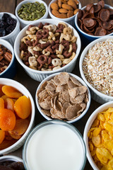 various cereals, nuts and dried fruits on wooden surface