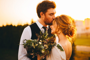 Wedding photos of charming lovers. Sunny summer day. Dry lavender flowers