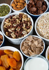 various cereals, nuts and dried fruits on wooden surface