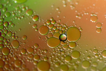 Oil Droplets On Water with Orange and Green Background