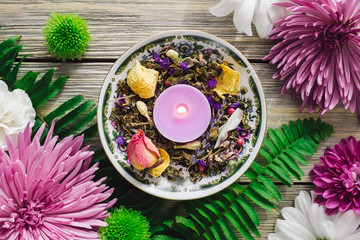 Purple Candle with Herbs and Spring Flowers - obrazy, fototapety, plakaty