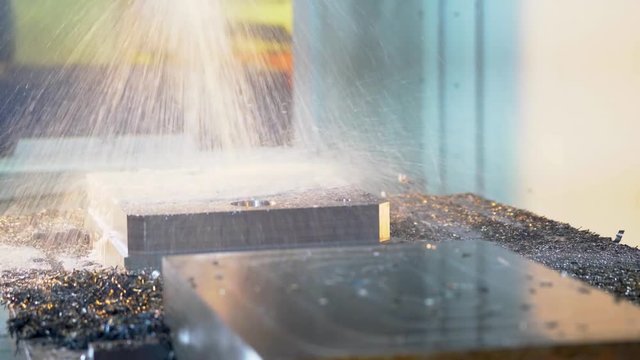 CNC milling machine in operation in a machine shop, cutting steel.